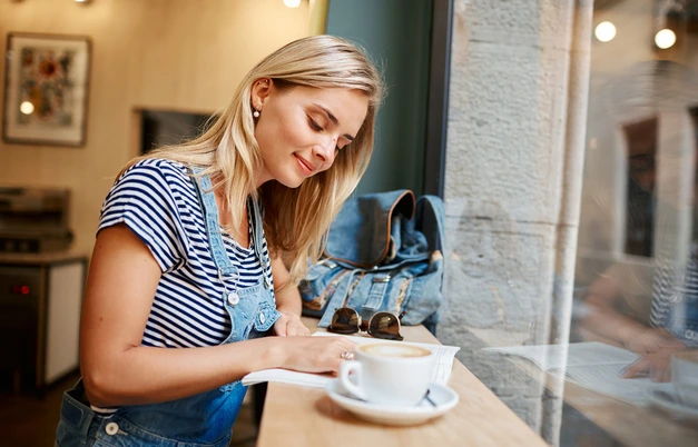 Customer reading a book with a latte at Brew & Bean
